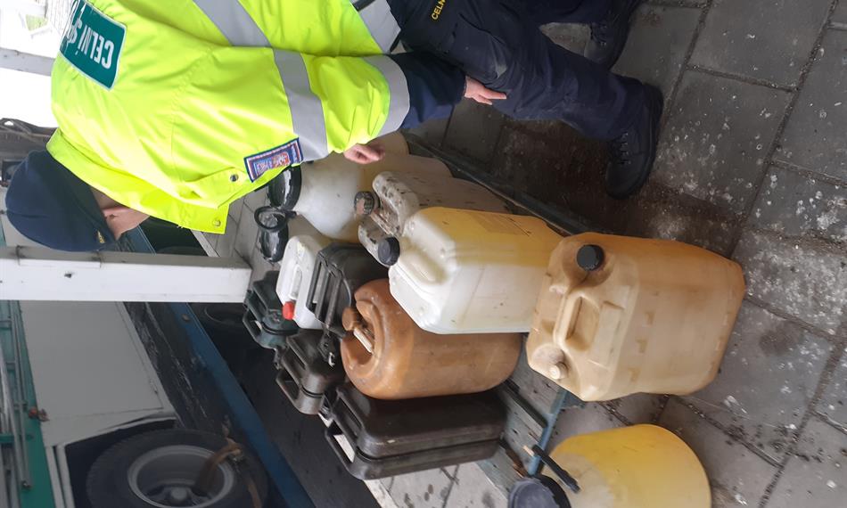 Celník kontroluje kanystry s PHM