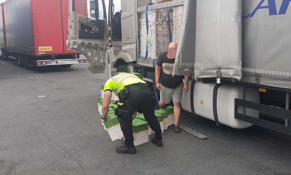 celník vykládá kartony s vínem