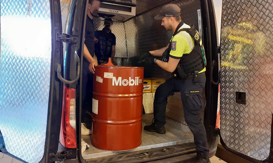 celníci vytahují sud z auta