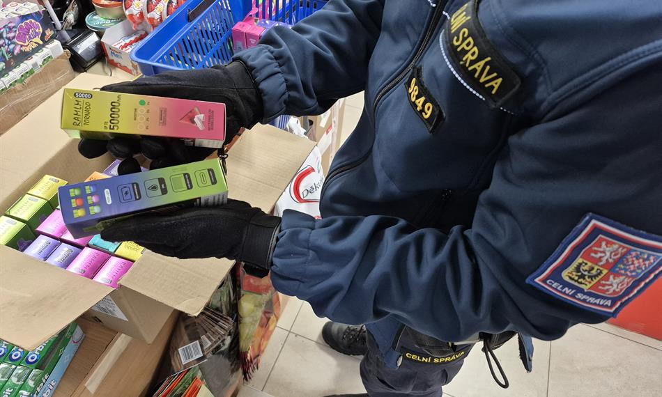 celník drží krabičky s el. cigaretami