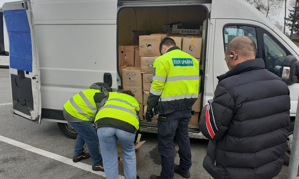 veterináři s celníkem otvírají krabice s masem