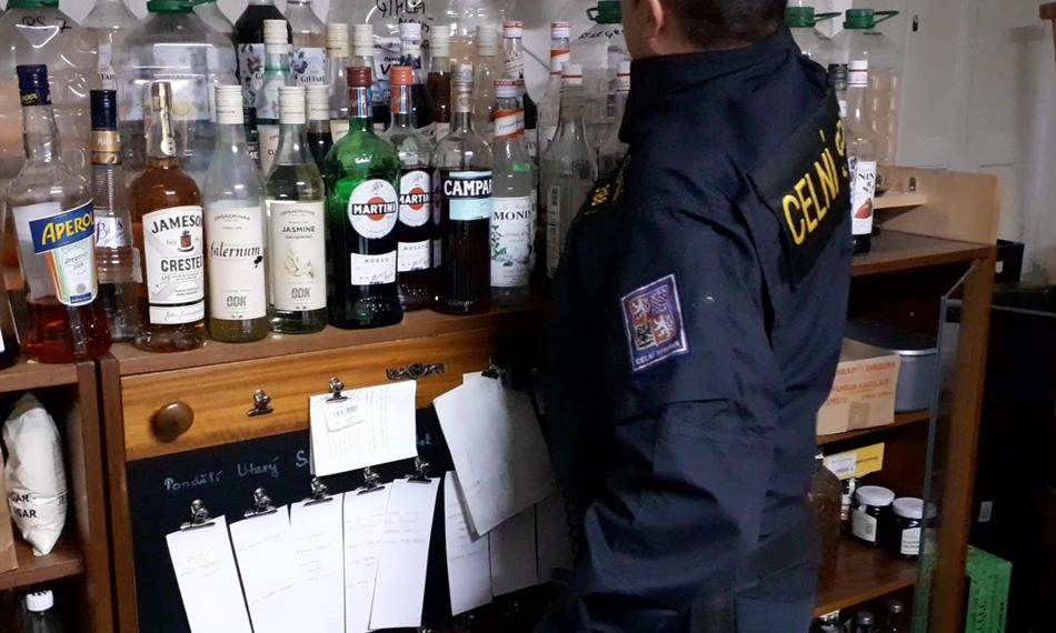 Celník kontroluje lahve s alkoholem