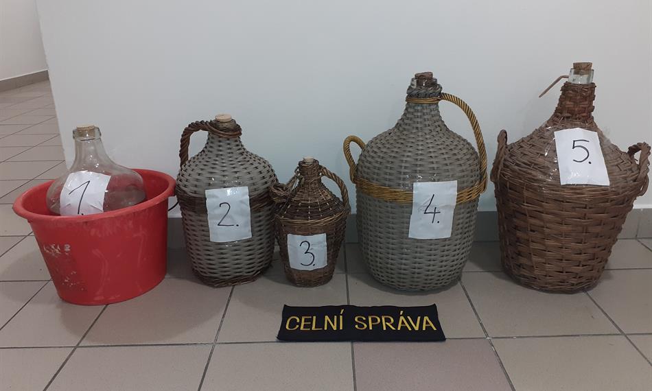 demižony s vypáleným ovocným destilátem