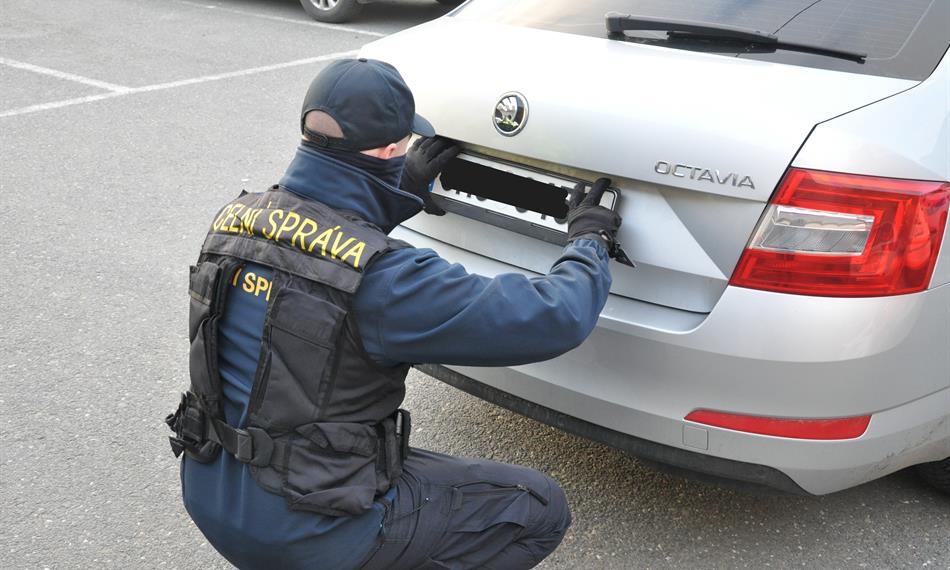 Celník odebírá registrační značku u vozidla