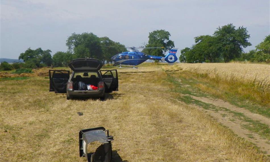 otevřené vozidlo a rozbitá popelnice v poli