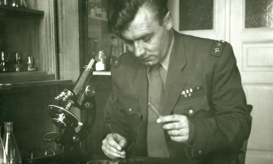 celník v dobové uniformě u mikroskopu